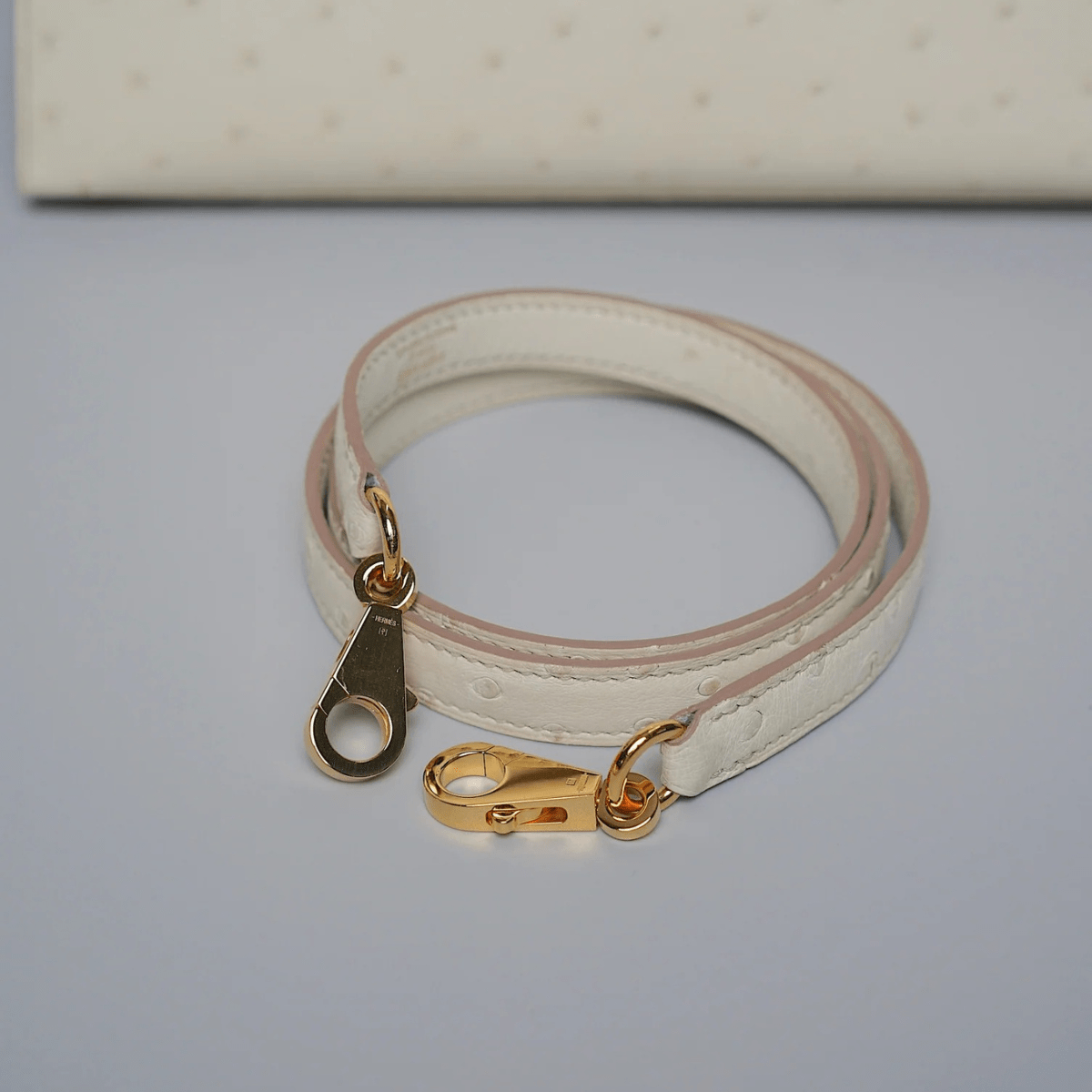 Hermès Kelly 25 in Beton Straußenleder mit goldener Hardware